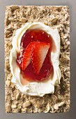 Cream cheese and strawberries on a sunflower seed crisp