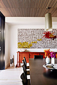 Large abstract painting above the red sideboard in the dining room