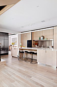 Open kitchen with light wooden fronts in the luxurious living room