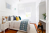 Bright bedroom with colorful pillows and a large wall unit