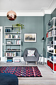 Simple shelves against petrol-blue walls in living room