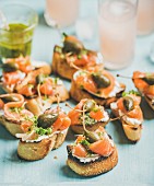Crostini with smoked salmon, pesto sauce, watercress and capers and pink grapefruit cocktails
