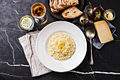 Risotto with parmesan cheese on plate on dark marble table background