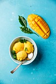 Mango ice cream sorbet with mint leaves and Fresh mango on blue background