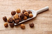 Energy balls with sunflower seeds, honey and cocoa on a wooden scoop