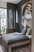 Bedroom in shades of grey with large artwork and neon lettering