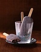 Chocolate ice creams on sticks in a glass