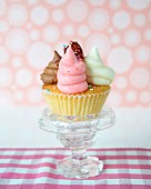 A cupcake with colourful cream and sugar sprinkles