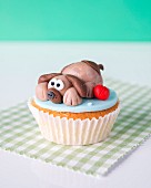 A cupcake with a marzipan dog on the top