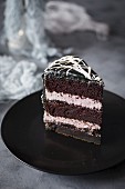 Ein Stück Halloween-Schokoladenkuchen mit Marshmallow-Spinnennetz