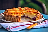 A cherry and ricotta tart with a slice cut out