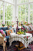 Colourful cushions on seats and round table in conservatory