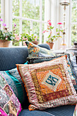 Colourful scatter cushions on sofa in conservatory