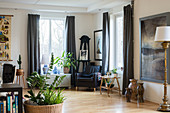 Armchair in corner between two windows in large living room