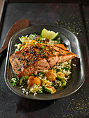 Grilled salmon fillet on a bed of couscous with vegetables