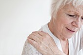 Senior woman rubbing sore shoulder