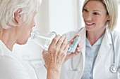 Senior woman using inhaler