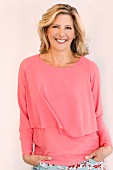 Blonde Frau in pinkfarbener Bluse