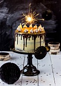 A brownie cheesecake decorated with a sparkler on the top