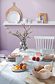 Vase of flowering magnolia on set breakfast table
