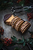 Vegan biscuits dipped in dark chocolate and filled with jam and chocolate cream