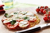 A pizza rosti with tomatoes, mozzarella and basil