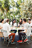 Junge Leute beim Essen auf sonniger Terrasse