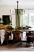 Wicker chairs around the wooden table in the dining room in brown and green