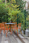 Orange metal chairs and table on wooden deck
