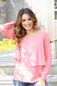 A young woman wearing a layered-look pink blouse
