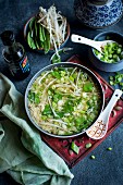 Asian-style egg soup with peas, sprouts, spring onion and soy sauce