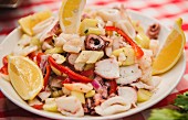 Seafood salad with lemon wedges