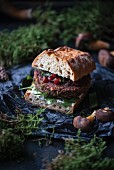A vegan sandwich with wild mushroom patty, herb cream and lingonberries