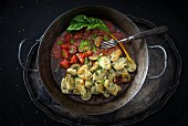 Vegan pan-fried swiss chard gnocchi with tomato and zucchini sauce