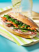 A banh mi sandwich with ham, cucumber, carrot and herbs (Vietnam)