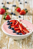 A smoothie bowl with strawberries and blueberries