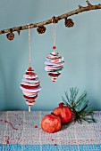 Baubles made from paper circles and beads hung from larch branch