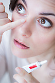 Woman applying eye ointment