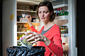 Woman throwing food in the trash