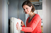 Woman adjusting a thermostatic radiator valve