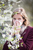 Woman with hay fever blowing her nose