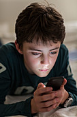 Teenage boy using a smartphone at night