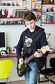 Teenage boy playing electric guitar