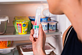 Woman checking temperature of a fridge
