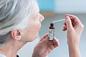 Woman using a Bach remedy (liquid flower extract)