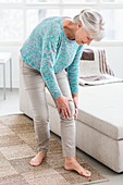 Senior woman suffering from a pain in the knee