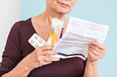 Woman reading medicine instruction sheet