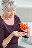 Woman taking food supplement capsules