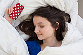 Teenage girl sleeping with her smartphone