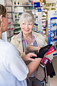 Pharmacist showing a customer support stockings